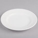 A white Reserve by Libbey Royal Rideau porcelain plate with a wide rim on a gray surface.