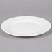 A white Reserve by Libbey porcelain plate with a wide rim on a gray surface.