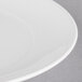 A close-up of a white Reserve by Libbey Royal Rideau coupe plate with a rim.