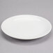 A white Reserve by Libbey porcelain coupe plate on a gray surface.