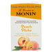 A carton of Monin Peach Fruit Smoothie Mix on a table.
