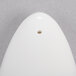 A white porcelain pepper shaker with a hole in it.