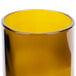An Arcoroc wine tumbler with a yellow liquid in it and a white background.
