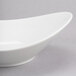 A close up of a white Reserve by Libbey Silk Oval Royal Rideau bowl on a gray surface.