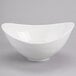 A white bowl with a curved edge on a gray surface.