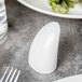 A white Libbey Royal Rideau porcelain salt shaker on a table.