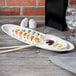A Reserve by Libbey oval porcelain tray with sushi, sauce, and chopsticks.