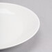 A close-up of a Reserve by Libbey white porcelain coupe plate with a white rim.