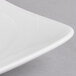 A close up of a white rectangular porcelain platter with a wavy design.