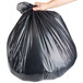 A person's hand holding a black Berry trash bag.
