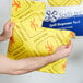 A man holding a yellow Spilfyter absorbent pad.