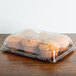 A Sabert clear plastic catering tray with muffins in it.