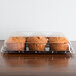 A Sabert clear plastic catering tray with muffins inside.