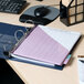 A navy blue Avery Heavy-Duty View binder on a desk with a pink paper on it.