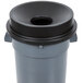 A gray trash can with a black funnel top lid.