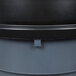 A close up of a black and grey cylinder trash can with a black lid.