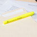 A Universal fluorescent yellow chisel tip highlighter on a file folder.