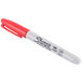 A close-up of a Sharpie red fine point marker with black writing on it.