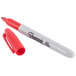 A close-up of a Sharpie red fine point marker with a white tip.