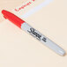 A red Sharpie marker writing on a white surface.