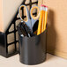 A black Universal pencil cup holding pencils and scissors.