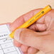 A person using a Universal yellow barrel HB lead pencil.