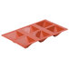 A red silicone baking tray with six pyramid-shaped compartments.