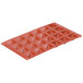 A red silicone mold with 24 triangular shapes.