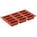 A red silicone Matfer Bourgeat mini cake mold with 12 compartments.