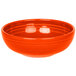 A white china bistro bowl with an orange interior and rim.