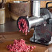 A Weston meat grinder with meat on it.