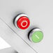 A white surface with a red and green button and a silver button.