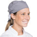 A woman wearing a houndstooth patterned chef bandana.