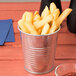 A close up of a bowl of french fries in a galvanized soup can.
