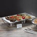 An American Metalcraft stainless steel rectangular tray with vegetables on a table.