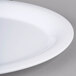 A close up of a white Carlisle melamine oval platter with a handle.