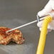 A person using a Cooper-Atkins DuraNeedle probe to check the temperature of a steak.