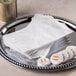 A silver tray with white Hoffmaster Linen-Like guest towels.