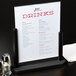 An American Metalcraft black table menu board with drinks on it sitting on a table.