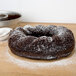 A chocolate bundt cake made with a Gobel Trois Freres mold with powdered sugar on top.