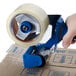 A person using a Shurtape Standard Pistol Grip packaging tape gun dispenser to seal a box.