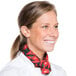 A woman in a chef's uniform wearing a red chili pepper patterned neckerchief.