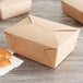 A brown Fold-Pak Bio-Plus-Earth paper take-out box with croissant and pastries inside.