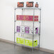 Metro Super Erecta wire shelving unit with boxes of various colors on it, including a green box with black text.