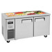 A Turbo Air refrigerated buffet display table with a stainless steel top on a counter with food on top.