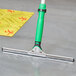 A green Unger ErgoTec XL squeegee handle on the floor.