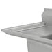 A stainless steel Advance Tabco three compartment sink with two drainboards on a counter.