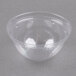 A clear plastic bowl with a Dart Conex clear plastic dome lid with a hole in the middle on a grey surface.