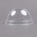 A clear plastic dome lid with a hole on top over a white surface with a black border.
