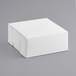 A 9" x 9" x 4" white bakery box with a lid on a gray surface.
